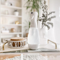 Nellie's One Bottle in a frosted glass reusable spray bottle on coffee table