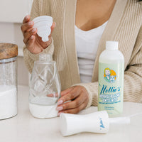Person filling their Nellie's One Bottle with Nellie's Wrinkle-B-Gone