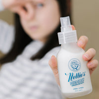 Kid holding toilet spray and plugging nose