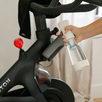 Person removing bacteria on Peloton using Nellie's Ninety-Nine