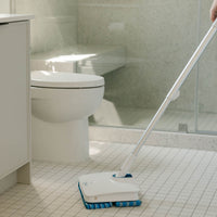 Person cleaning bathroom tiles with Wow Too Mop.