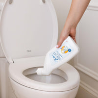 Hand squirting Nellie's Toilet Bowl Cleaner into toilet bowl