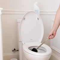 Person cleaning toilet with Nellie's Toilet Bowl Cleaner and toilet brush