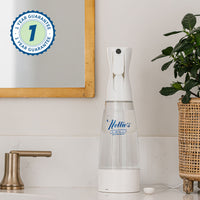 Nellie's Ninety-Nine placed on a bathroom counter, with a plant and a framed mirror in the background.