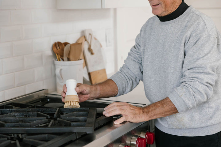 Man cleaning stove with Nellie's Dish Stick.