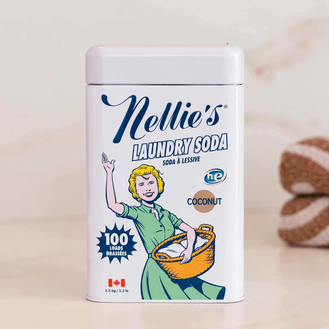 Nellie's Laundry Soda, Coconut scent, in a 100-load tin on a clean, white counter. 